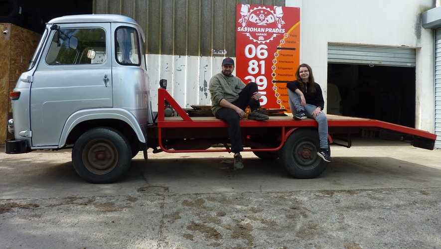 Charlène et Johan assis sur un camion restauré devant le garage johan-prades-garage dans le Tarn